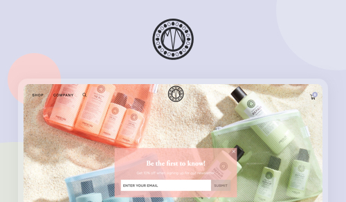 The image shows a website landing page for a skincare or beauty brand, featuring their products arranged on a sandy surfac...