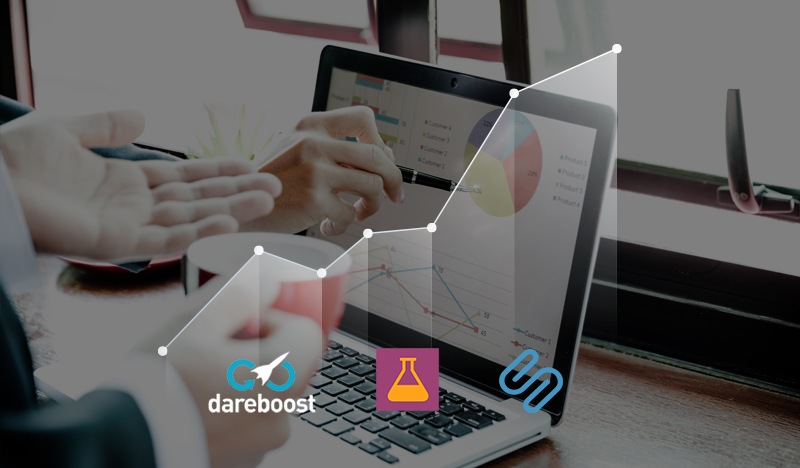 The image shows a person pointing at a laptop screen displaying various charts, including pie and line charts, indicating ...