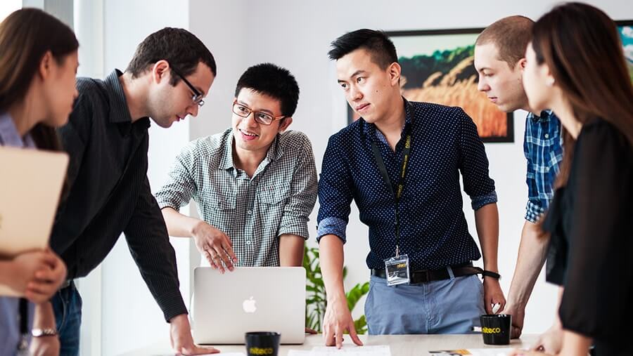 Team collaborating around laptop during a productive business meeting