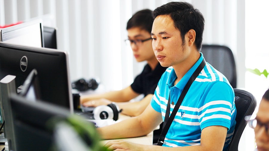 Young professionals focused on computer programming in modern office environment
