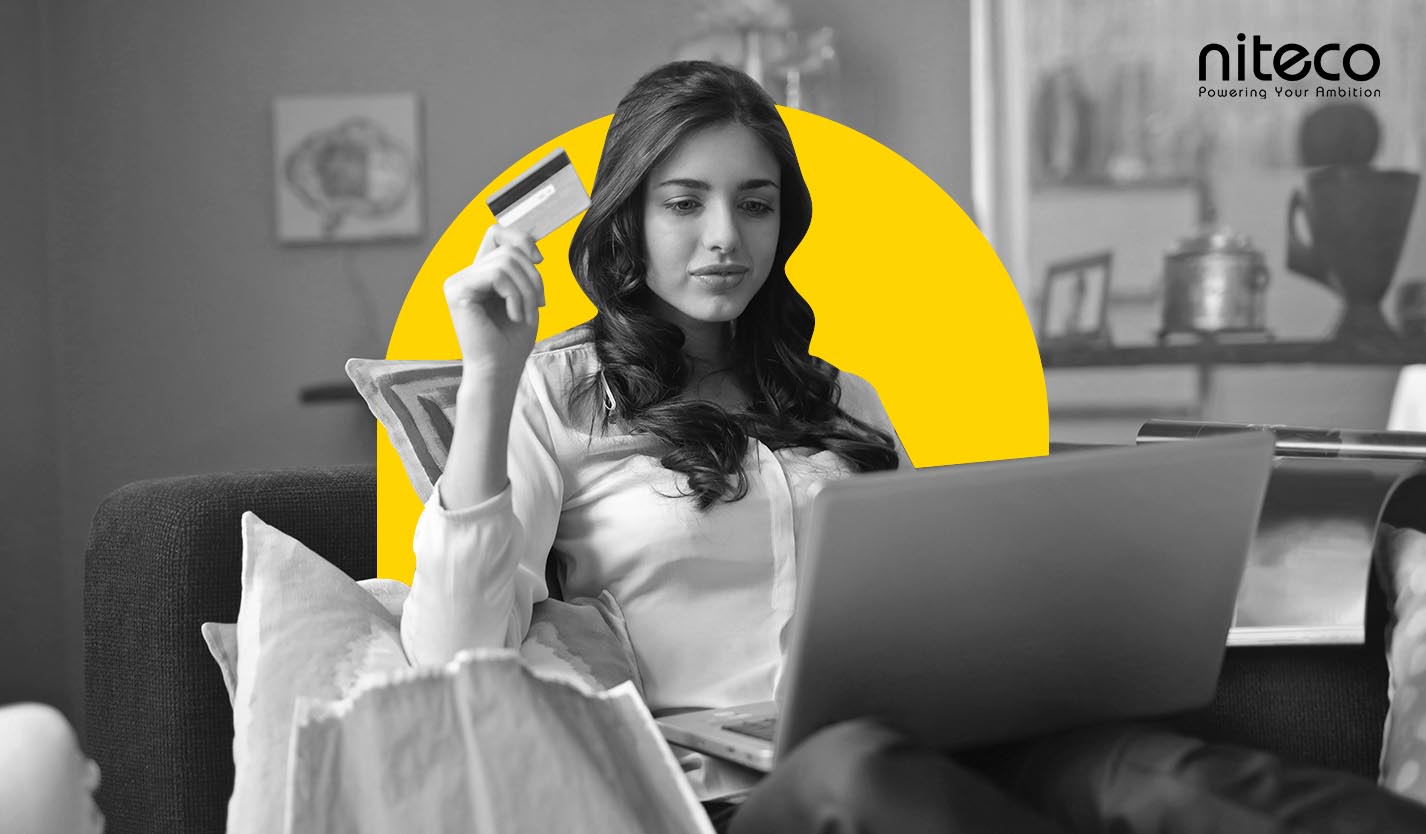 Young woman using laptop and credit card for online payment at home