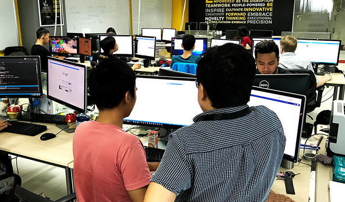 Teamwork and innovation in a collaborative office with multiple computer screens
