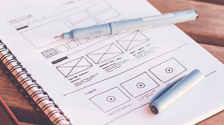 Wireframe sketches and layout planning for web design on a notebook page