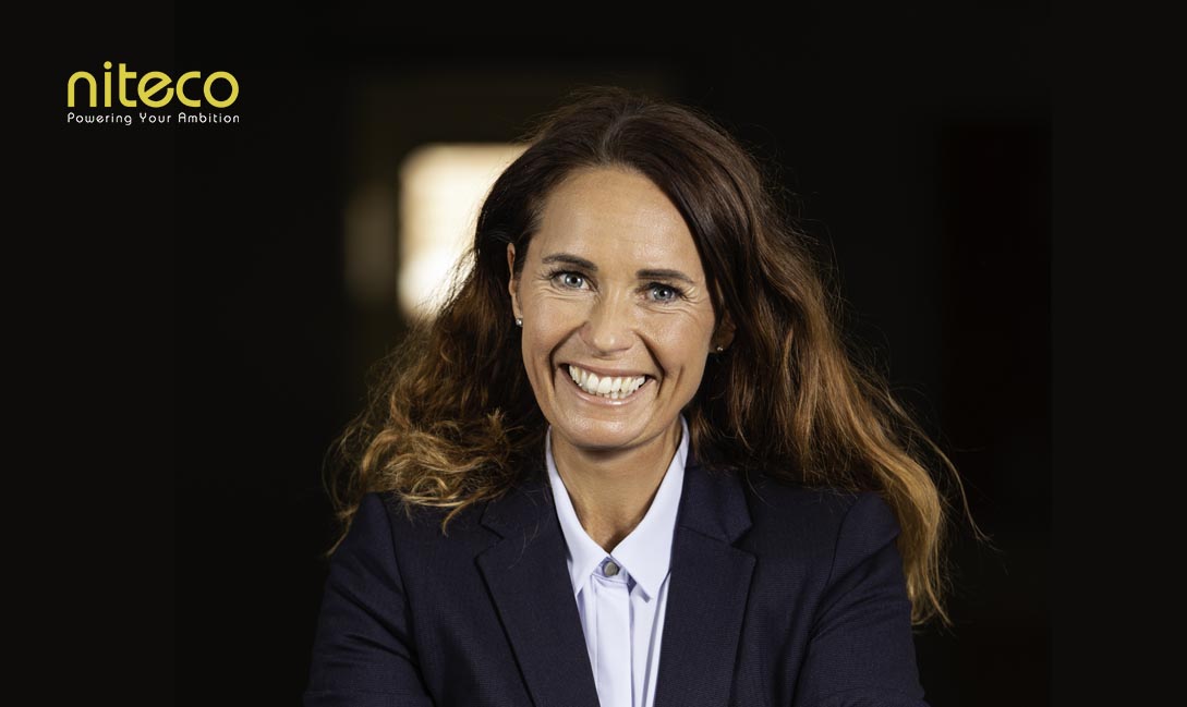 Smiling businesswoman in blazer representing Niteco's ambition and leadership