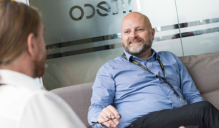 Two colleagues having a discussion in an office with Cisco branding